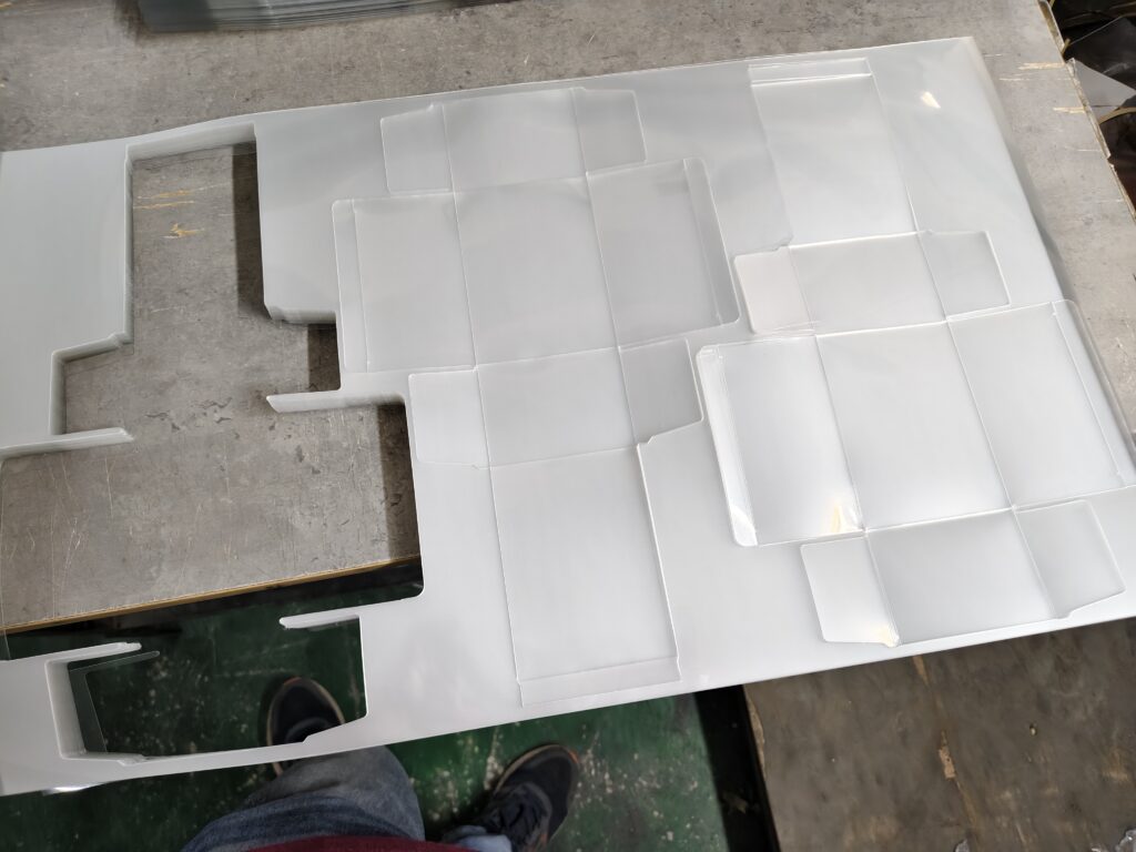 Three die-cut PET packaging box blanks arranged on one plastic sheet